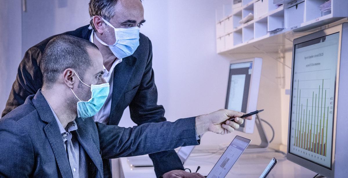 Impiegati lavorano su pc con mascherina - Foto di alex.pin da Adobe Stock