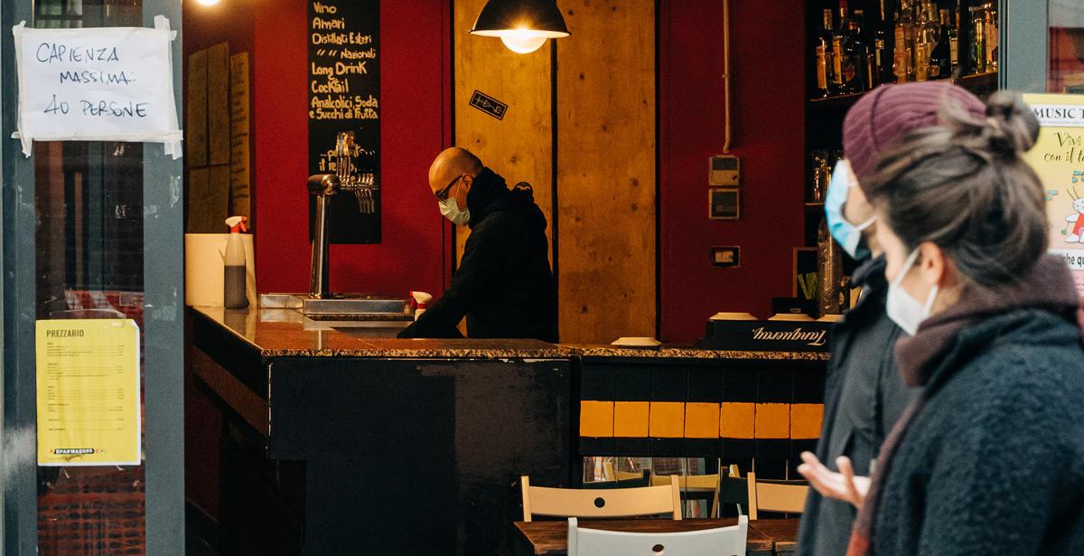 Due ragazze passano davanti ad un pub vuoto - Foto di Gabriella Clare Marino da Unsplash