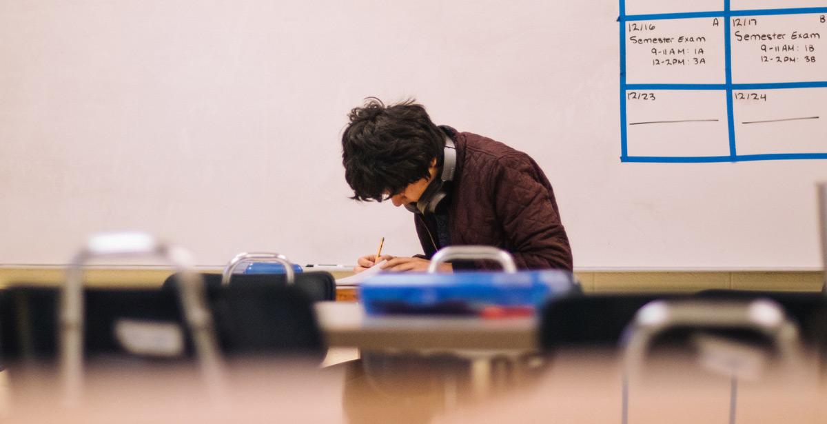Studente impegnato sui libri in aula - Photo by Jeswin Thomas on Unsplash