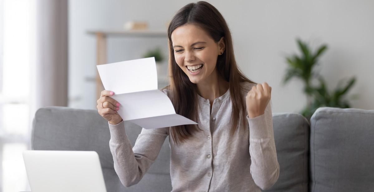 Studentessa entusiasta con lettera in mano - Foto di fizkes da Adobe Stock