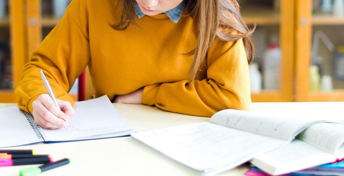 Ragazza impegnata con libri e quaderni per la scuola - Foto di andreaobzerova da Adobe Stock