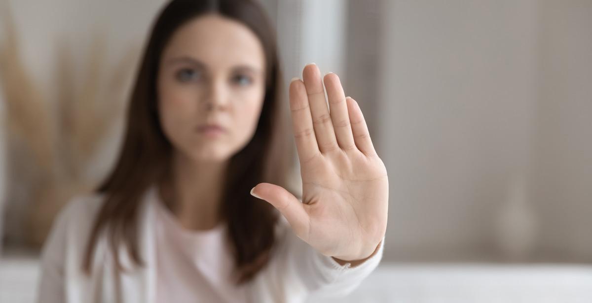 Ragazza con mano protesa come stop contro la violenza - Foto di fizkes da Adobe Stock