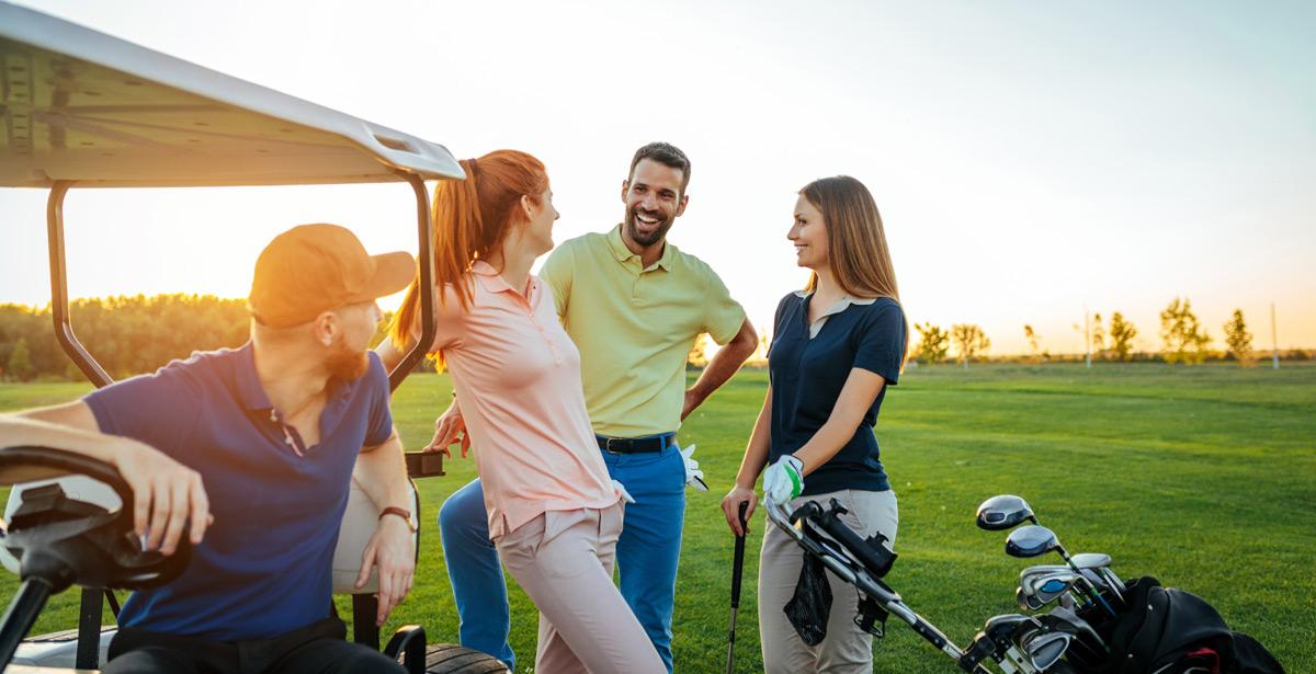 Due coppie di golfisti parlano sul campo al tramonto - Foto di bernardbodo da Adob Stock