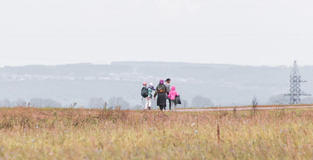 Famiglia di rifugiati Afgani camminano in lontananza - Foto di zatevakhin da Adobe Stock