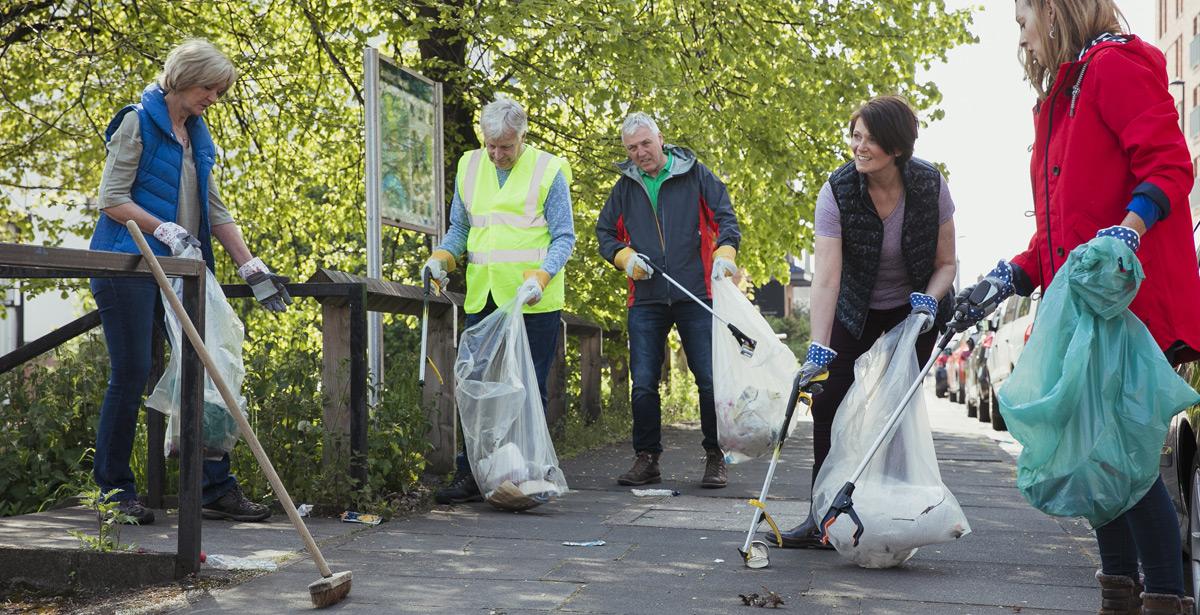 Cittadini impegnati nella pulizia di una zona urbana - Foto di dglimages da Adob Stock