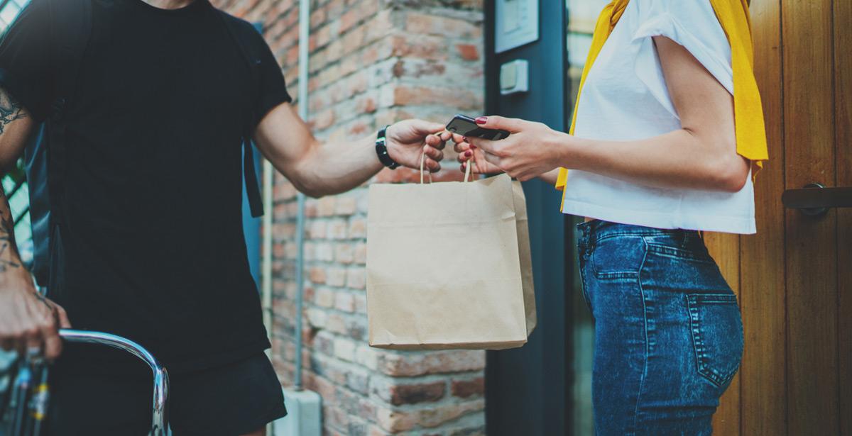 Rider consegna cibo a domicilio ad una ragazza - Foto di SFIO CRACHO da Adobe Stock
