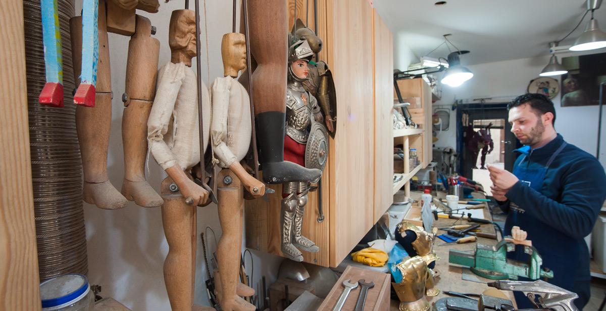 Artigiano al lavoro sui pupi siciliani - Foto di siculodoc da Adobe Stock