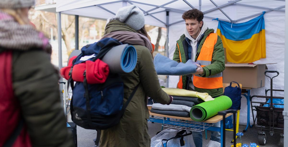 Volontario distribuisce coperte a migranti Ucraini - Foto di Halfpoint da Adobe Stock