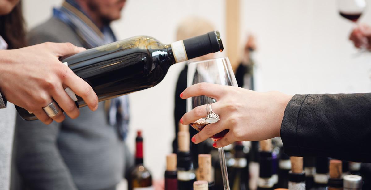 Giovane sommelier versa del vino rosso in un calice - Foto di Alessandro Cristiano da Adobe Stock
