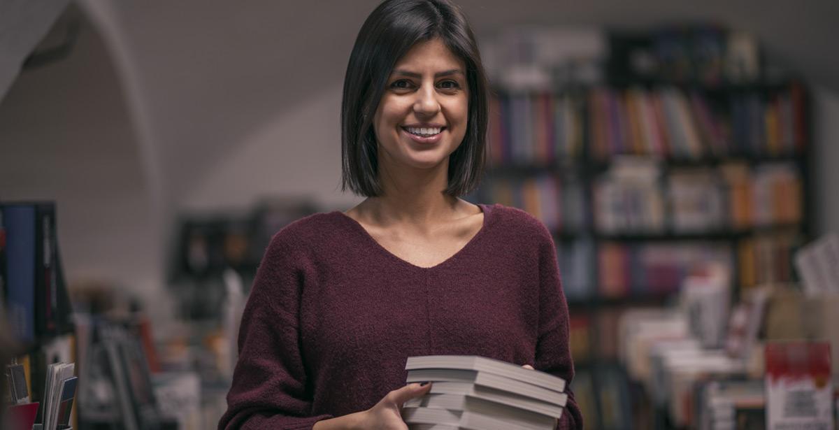 Giovane titolare di libreria con libri in mano - Foto di Vladimir Borovic da Adobe Stock