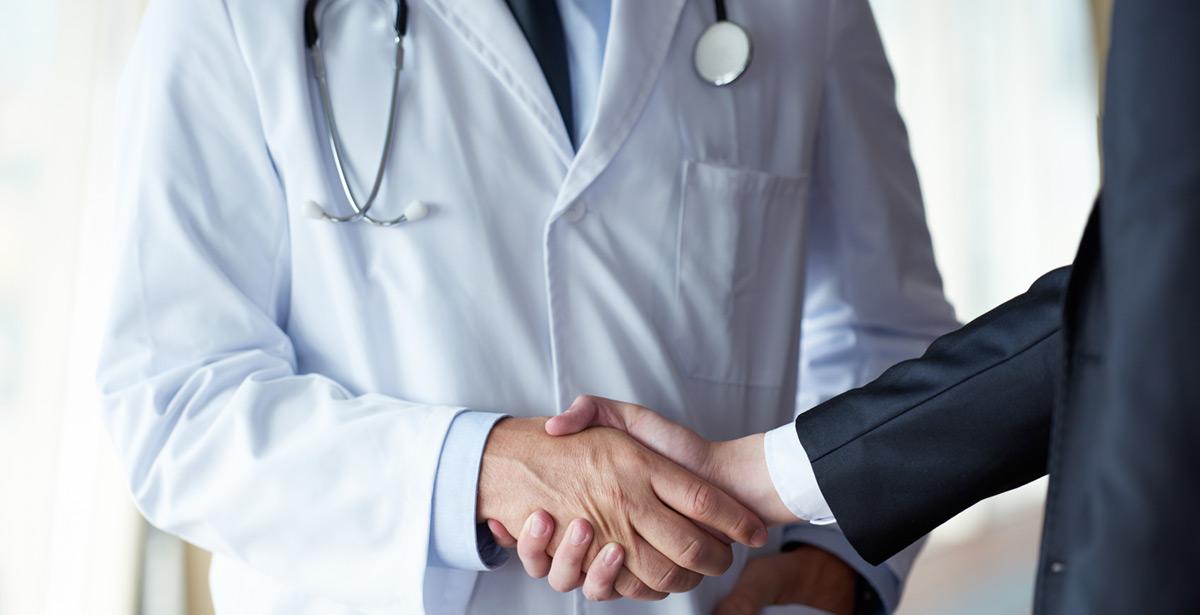 Medico stringe la mano con dirigente - Foto di shock da Adobe Stock