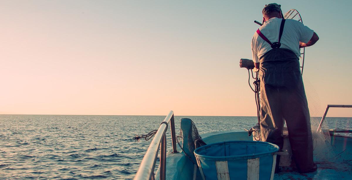 Pescatore ritira le reti al tramonto - Foto di Vitte Yevhen da Adobe Stock