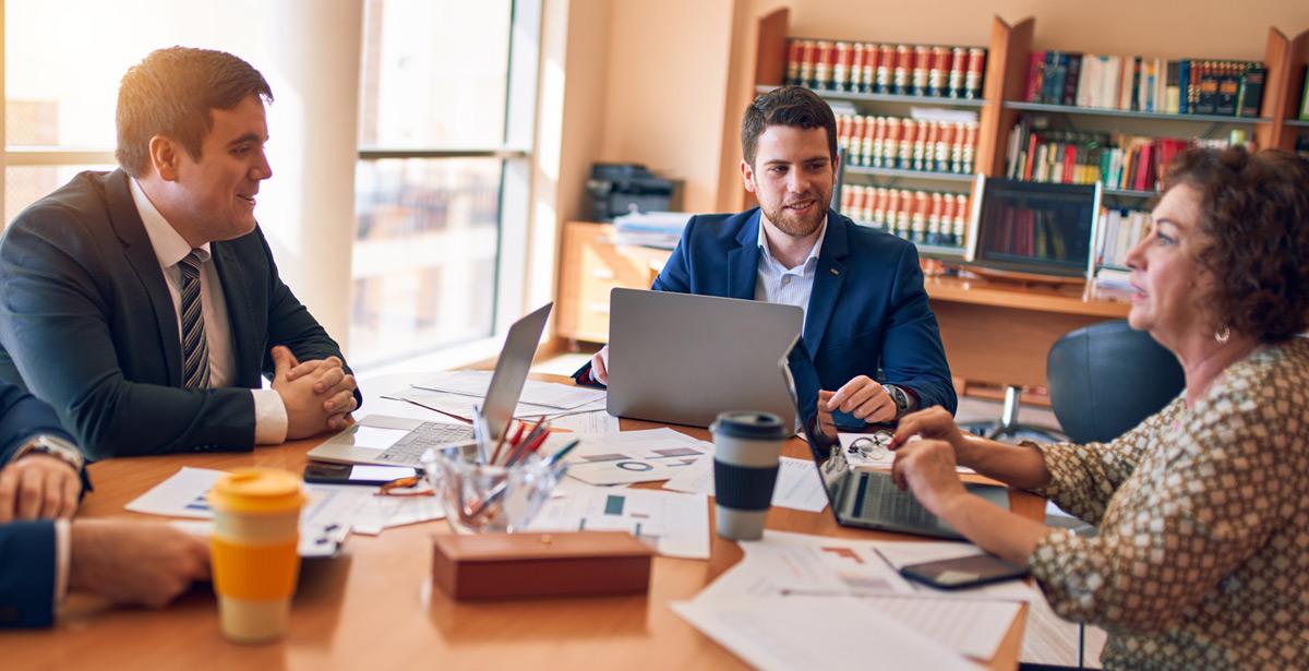 Impiegati e clienti impegnati al tavolo di lavoro - foto di Krakenimages.com da Adobe Stock