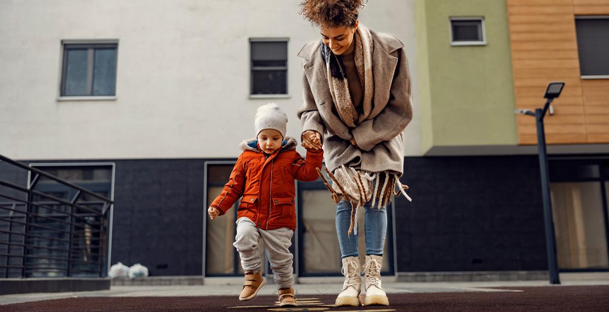 Baby sitter insegna ad un bambino come giocare a campana - Foto di dusanpetkovic1 da Adobe Stock