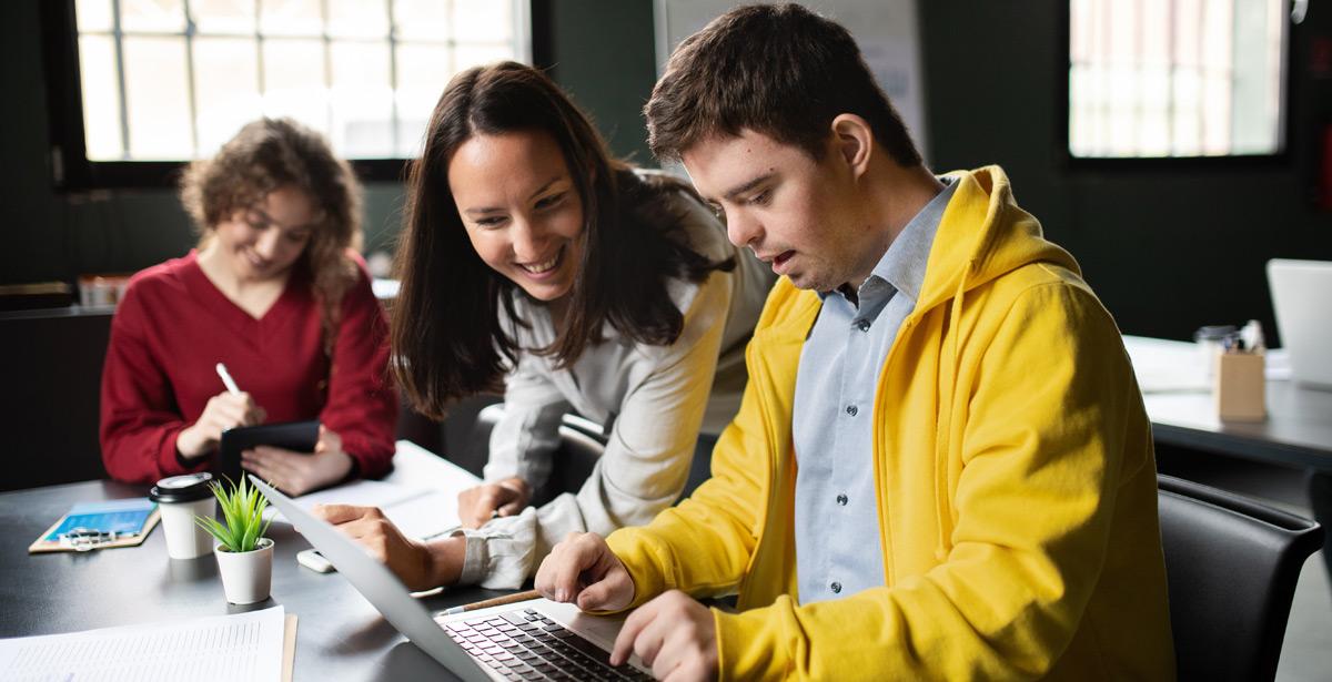 Ragazzo disabile davanti ad un portatile con altre persone - foto di Halfpoint da adobe stock
