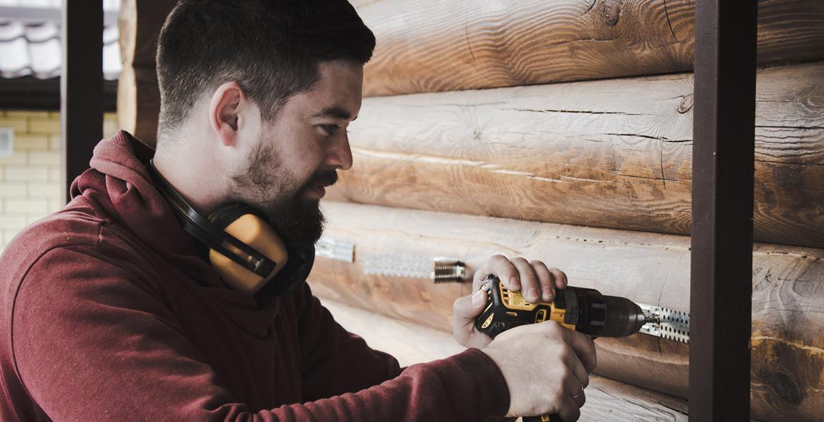 Operaio sistema delle staffe su box in legno - Foto di James Kovin da Unsplash