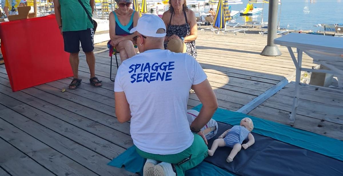 Istruttore mostra ad alcuni bagnanti come operare il primo soccorso in spiaggia